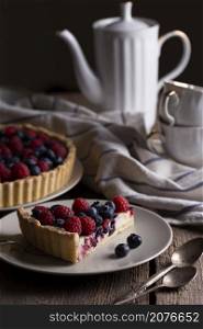 berry pie with raspberries and blueberries on the background of retro cups and teapot