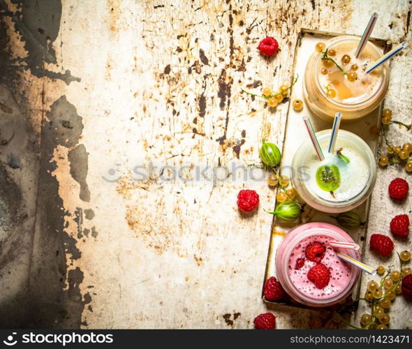 Berry smoothie gooseberries, raspberries and white currants. On rustic background.. Berry smoothie gooseberries, raspberries and white currants.