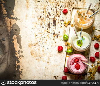 Berry smoothie gooseberries, raspberries and white currants. On rustic background.. Berry smoothie gooseberries, raspberries and white currants.