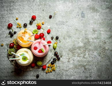 Berry smoothie made from raspberries, currants and gooseberries. On a stone background.. Berry smoothie made from raspberries, currants and gooseberries.