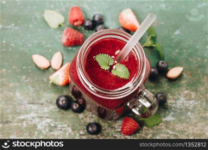 Berry smoothie on rustic background - Healthy eating, Detox or Diet concept. Berry smoothie on rustic background, top view