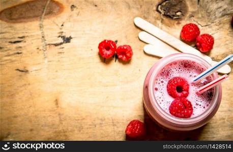 Berry smoothie raspberry with wooden sticks. On wooden background.. Berry smoothie raspberry with wooden sticks.