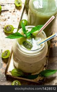 Berry smoothie with mint and gooseberry. On rustic background.. Berry smoothie with mint and gooseberry.