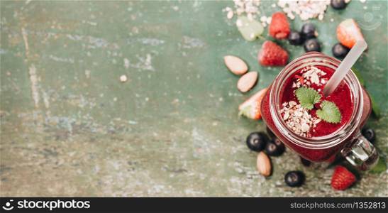 Berry smoothie with muesli and nuts on rustic background - Healthy eating, Detox, Diet, Perfect breacfast concept. Berry smoothie on rustic background, copy space