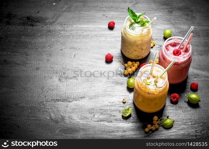 Berry smoothies with different berries. On the black chalkboard.. Berry smoothies with different berries.