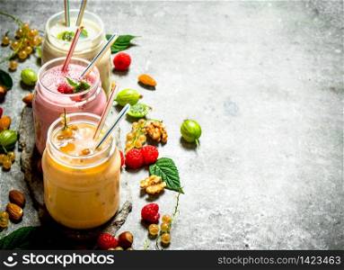 Berry smoothies with nuts. On a stone background.. Berry smoothies with nuts.