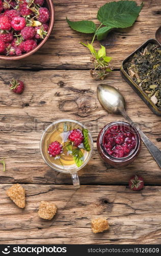 berry tea with raspberries. Autumn warming and tea with raspberries on vintage wooden background