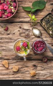 berry tea with raspberries. Autumn warming and tea with raspberries on vintage wooden background