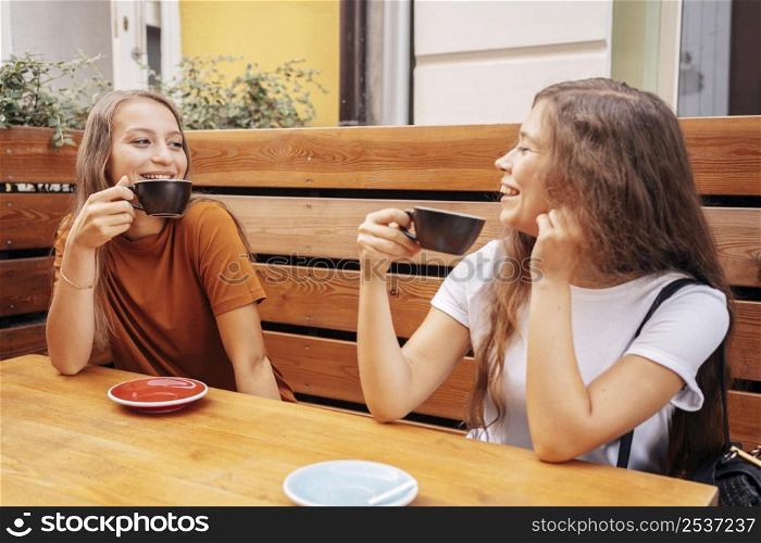 best friends drinking coffee together outdoors