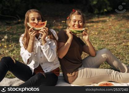 best friends eating watermelon outdoors