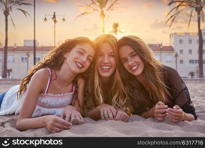 Best friends girls at sunset beach sand smiling happy together