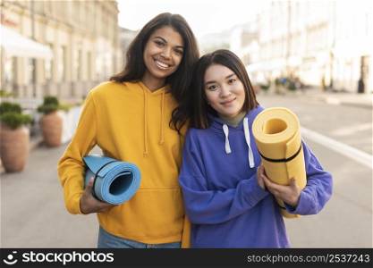 best friends holding fitness mats