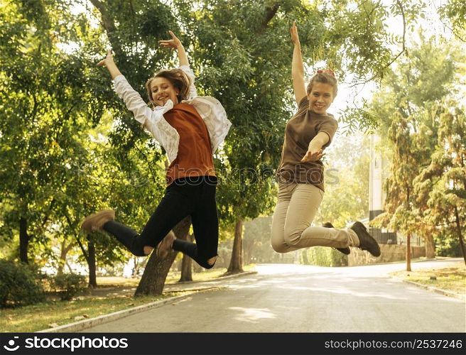 best friends jumping outdoors
