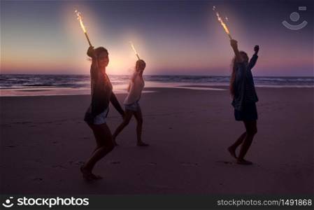 Best friends running on the beach celebrating the summer with fireworks