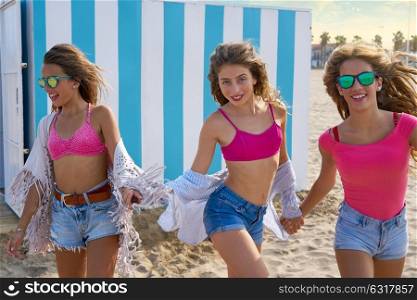 Best friends teen girls group running happy in a beach having fun