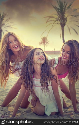 Best friends teen girls having fun on a beach sand at sunset