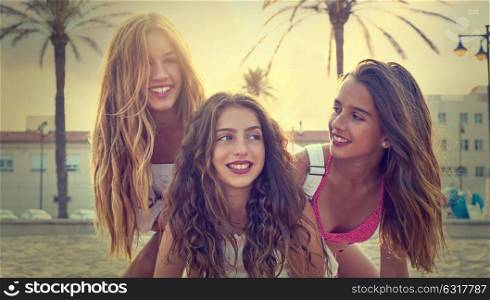 Best friends teen girls having fun on a beach sand at sunset