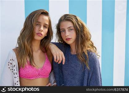 Best friends teen girls portrait in a summer blue stripes background