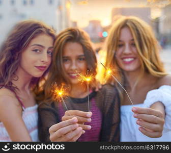 Best friends teen girls with sparklers at sunset in the city