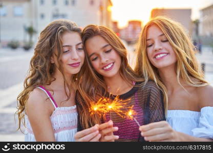 Best friends teen girls with sparklers at sunset in the city