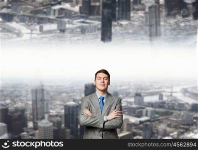 Between two parts. Young confident businessman with hands crossed on chest