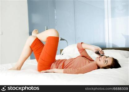 Beutiful happy woman in pajama talking at mobile phone