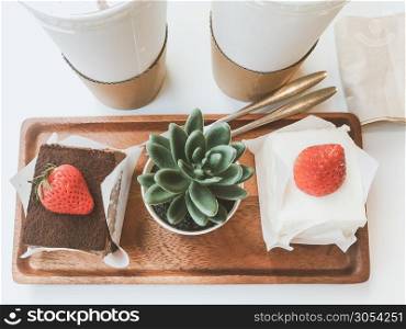 beverages and desserts concept from chocolate cake topping with fresh strawberry and drinks placed on table in cafe. top view