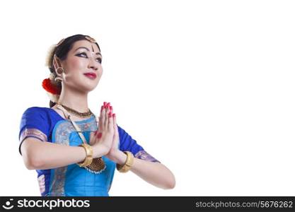 Bharatanatyam dancer in prayer position over white background