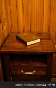 bible on bed side table in cheap hotel room