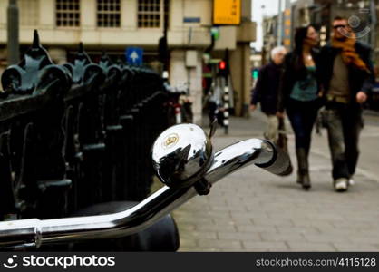 Bicycle bell and couple walking in Amsterdam streets