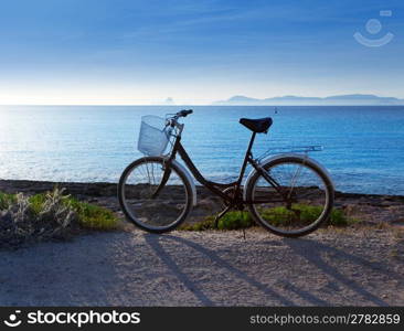 Bicycle in formentera beach on Balearic islands with Ibiza sunset background