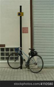 Bicycle locked to post in urban street