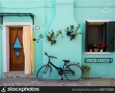 Bicycle near turquoise house on the venetian island Burano, Italy