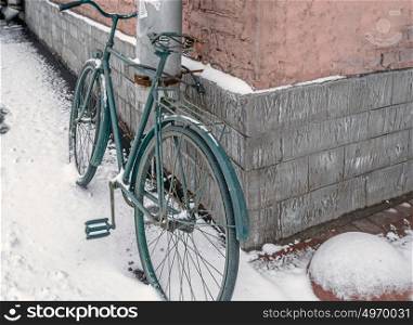 Bicycle near wall in winter time