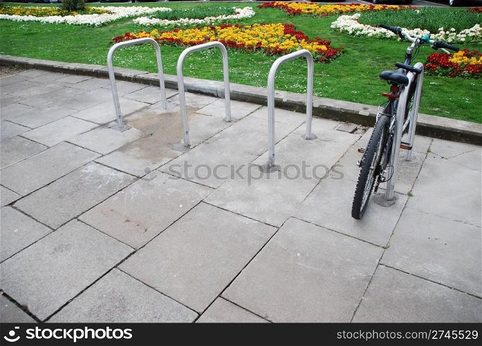 bicycle on a parking rack at a urban street (beautiful garden background)