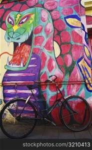 Bicycle parked against a painted wall, Amsterdam, Netherlands