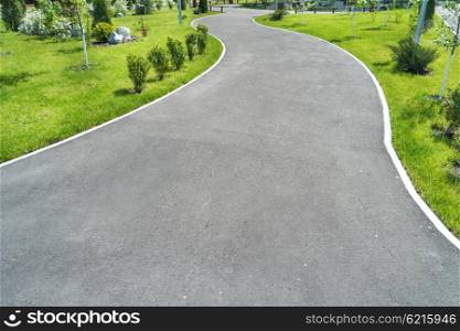 Bicycle road in the green park with green grass