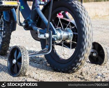 Bicycle with supporting wheels stuck in loose gravel