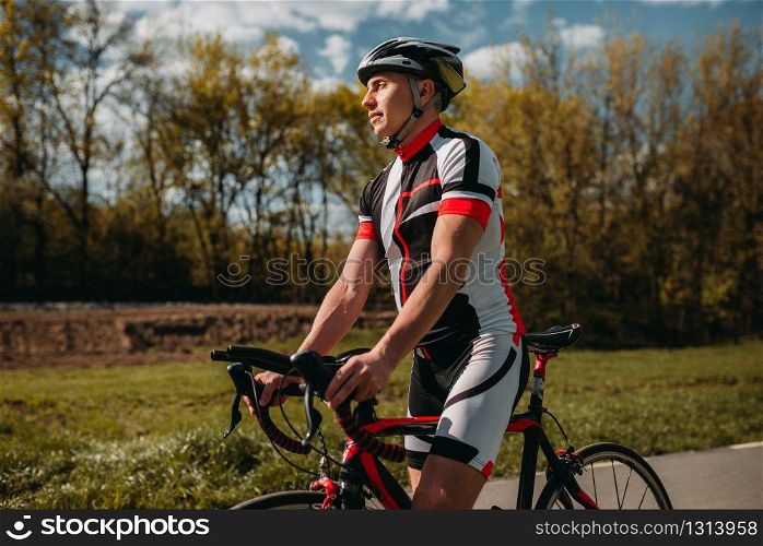 Bicyclist in helmet and sportswear on sport bicycle. Training on bike path, cycling workout