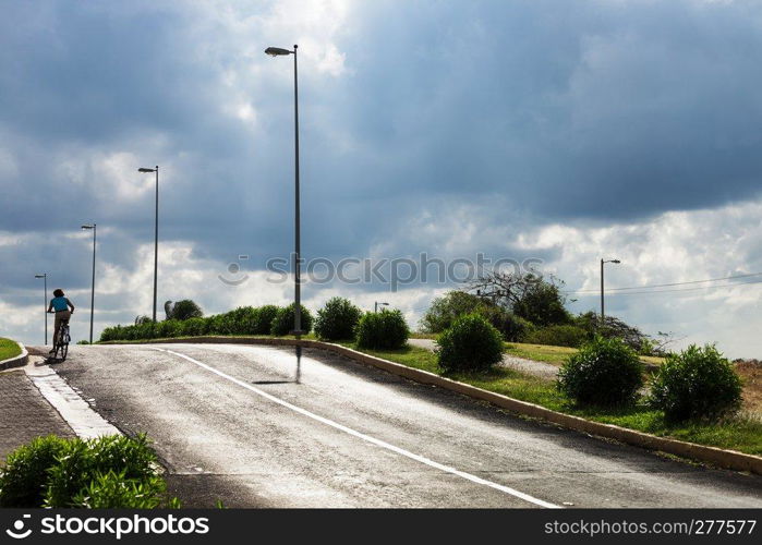 bicyclist on the asphalt road on a summer day