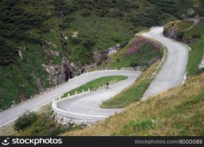 Bicyclist on the serpantin road in Swiss Alps in Switzerland