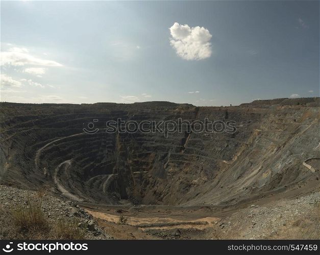 Big Abandoned opencast mining quarry against cloud sky.. Opencast mining quarry. Timelapse