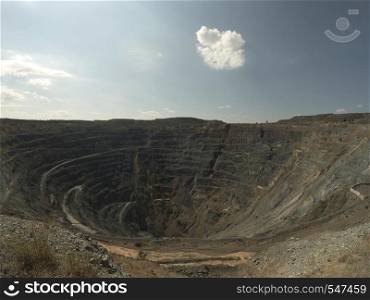 Big Abandoned opencast mining quarry against cloud sky.. Opencast mining quarry. Timelapse