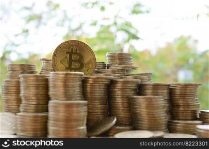 Big amount of bitcoin stacks on blurred green trees background close up. Cryptocurrency trading concept. Big amount of bitcoin stacks on blurred green trees background. Cryptocurrency trading concept