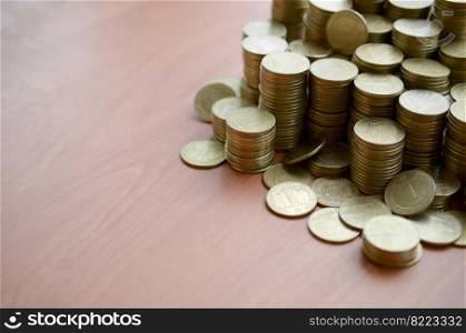 Big amount of shiny ukrainian old 1 hryvnia coins close up on wooden table background. The concept of business and rich life in Ukraine. Big amount of shiny ukrainian old 1 hryvnia coins close up on wooden table. The concept of business and rich life in Ukraine