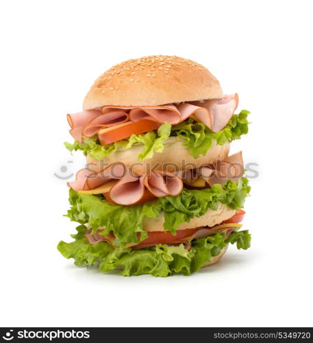 Big appetizing fast food sandwich with lettuce, tomato, smoked ham and cheese isolated on white background. Junk food hamburger.