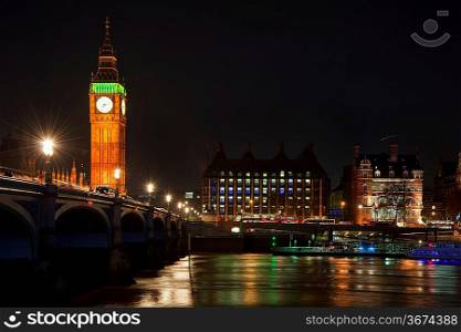 Big Ben and Westminster Bridge in London at night reflected in River Thames