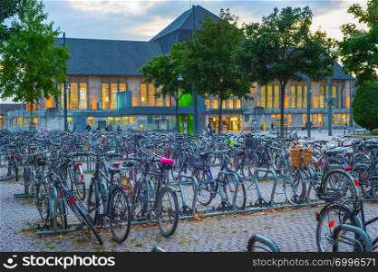 Big bicycles parking by train station in susnet dusk, Dortmund, Germany