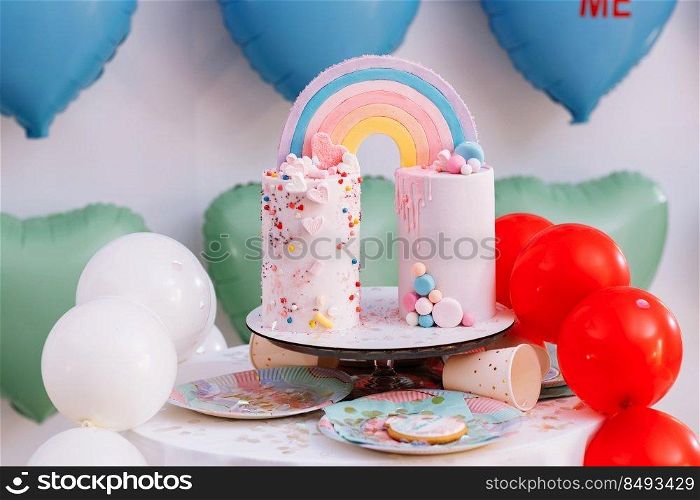big Birthday cake with rainbow, colorful Sprinkles. on many colorful heart balloons background. birthday party. sweet holiday. big Birthday cake with rainbow, colorful Sprinkles. on many colorful heart balloons background. birthday party. sweet holiday.
