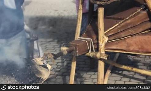 big blacksmith furs blow on hot coals, close-up